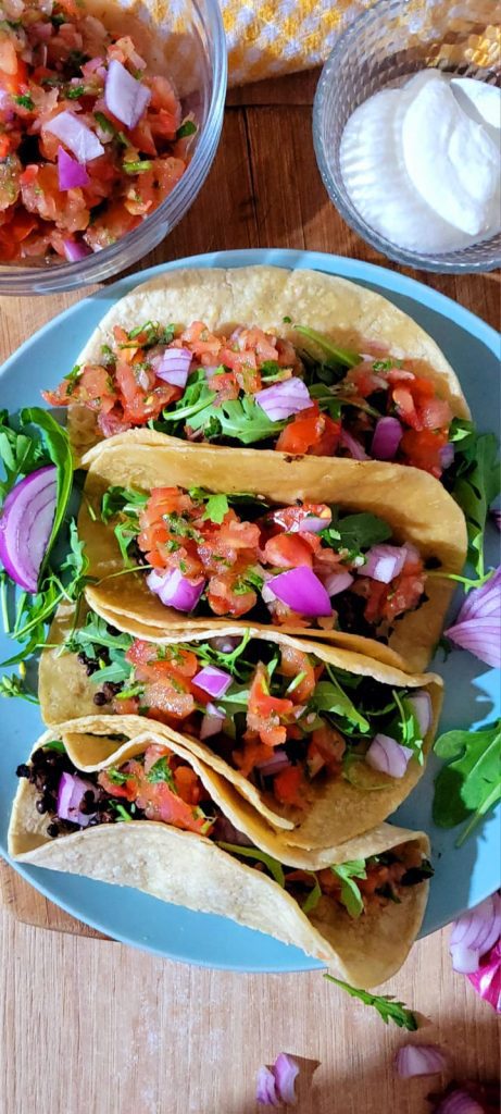 Black lentil tacos with red onion and fresh tomato
